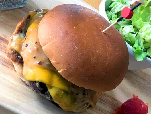 Pain burger, steak haché, fromage, légumes, sauce